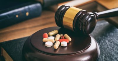 Judge gavel and drugs on a wooden desk
